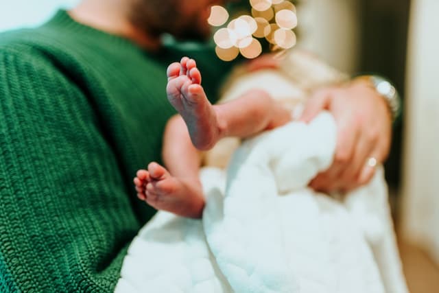 A baby held in his father's arms